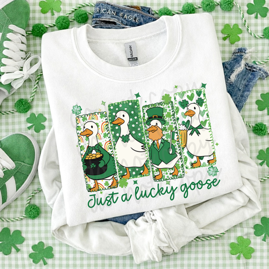 Just a Lucky Goose St. Patrick’s Day graphic tee featuring four festive geese with shamrocks, leprechaun hat, pot of gold, and green accents on white Bella Canvas or Comfort Colors shirt.