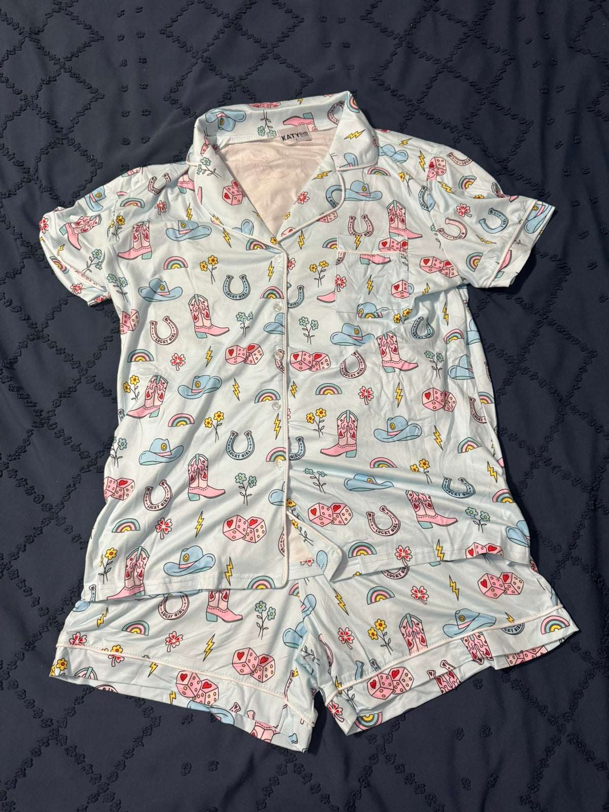 Women's pajama set with cowgirl pattern on a dark quilted surface